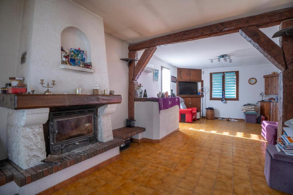a living room with a fireplace in a room at Villa Arbre de Vie in La Crau