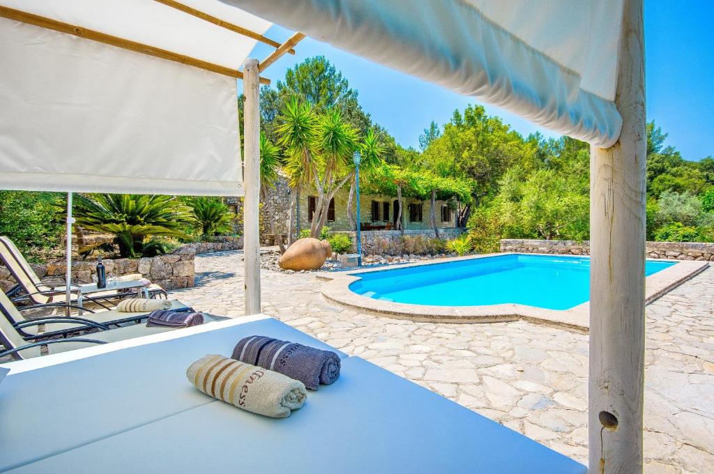a patio with a table and a swimming pool at Na Garrovera in Pollença