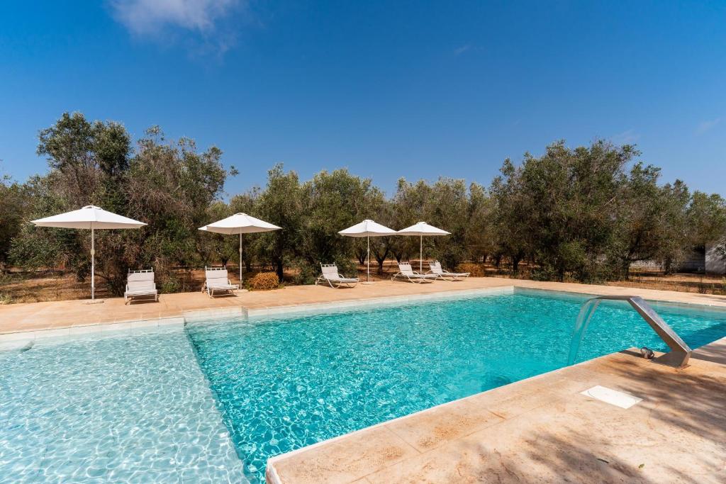 a large swimming pool with chairs and umbrellas at Domus mea salento Arazzo Giallo in Ugento
