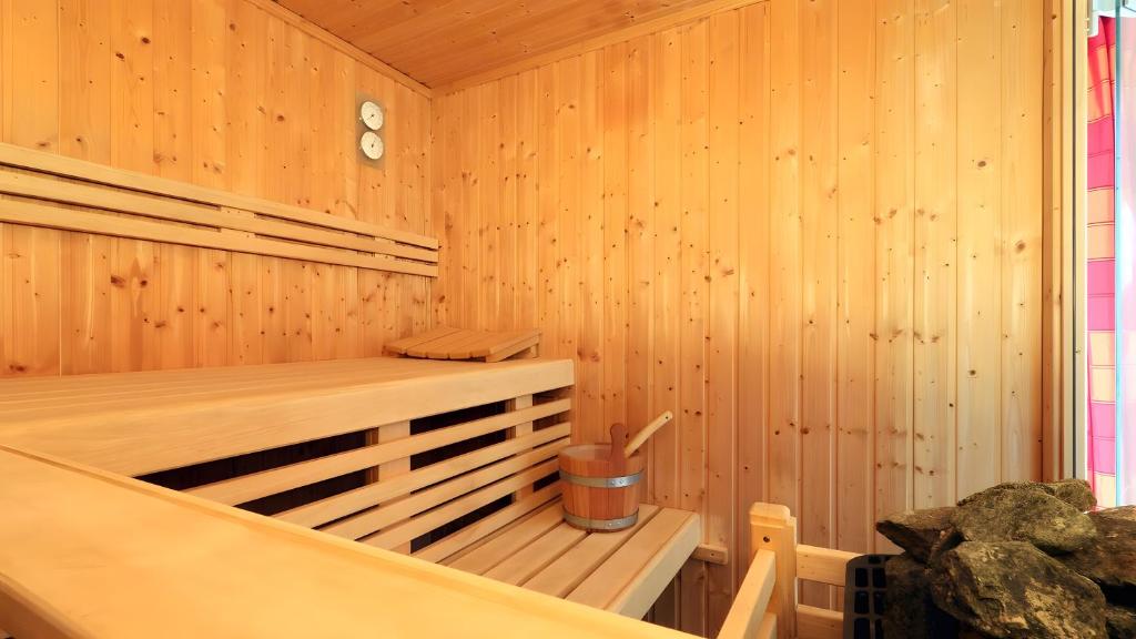 a wooden sauna with a trash can in it at Waldfee - Stilvolles Ferienhaus in Kemmerode