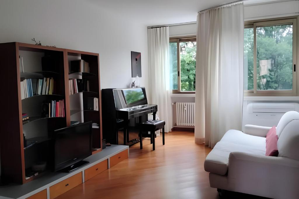a living room with a couch and a television and a piano at Residenza sul Livenza in Sacile