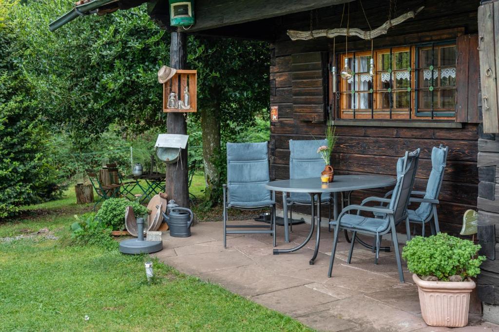 a patio with chairs and a table in front of a cabin at Blockhaus Paepke in Mühlenbach