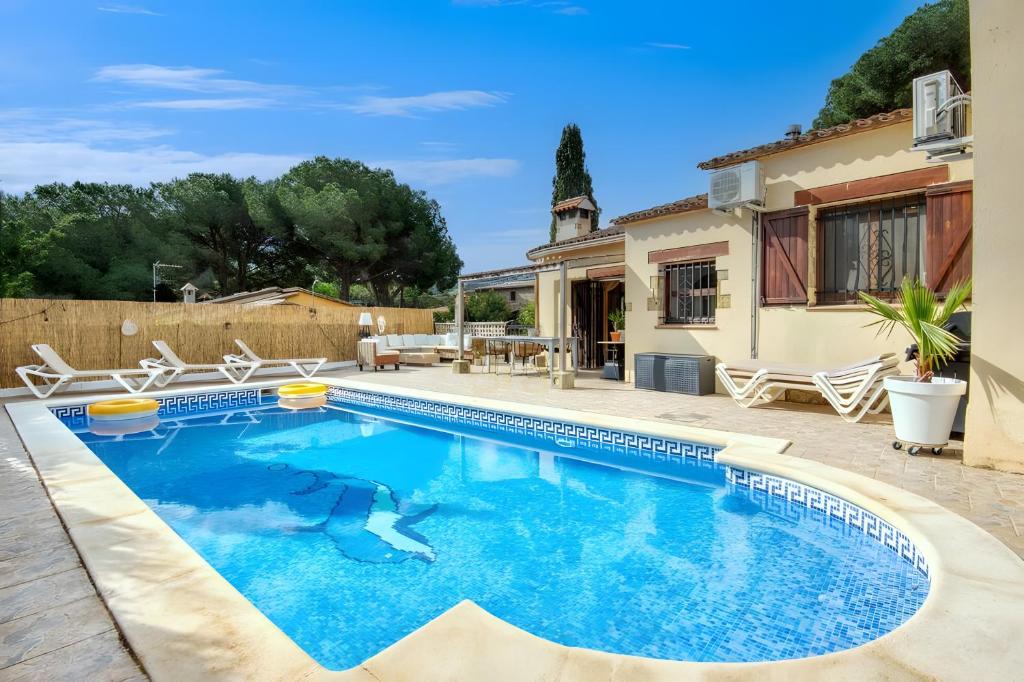 a swimming pool in front of a house at Villa Pura Vida by Easy Brava in Calonge