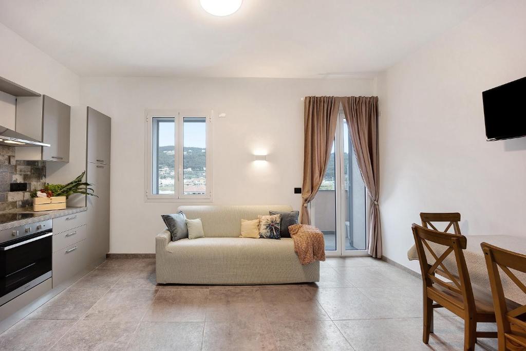 a living room with a couch and a kitchen at Antichi Ricordi - Il Nido in Marina di Andora