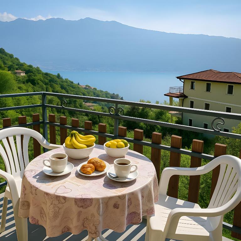 a table with bowls of fruit on a balcony at Vista Lago Casa Demonti in Tignale