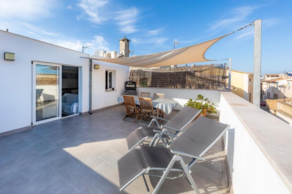 a patio with chairs and a table on a roof at Casa Coronel Aloy in Pollença
