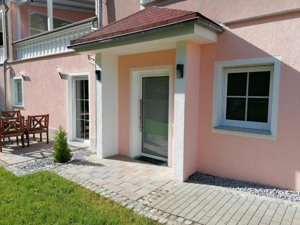 a pink house with a door and a patio at Villa am Bacho in Dörzbach