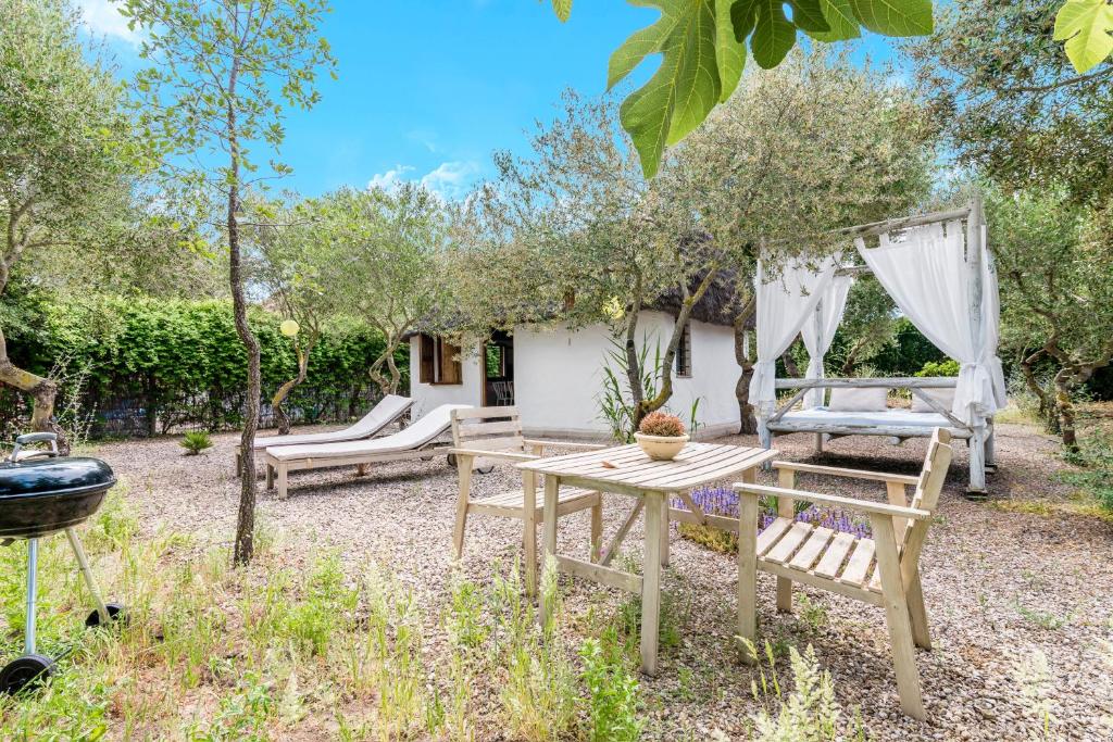 a patio with a table and chairs and trees at Casa La Castañuela in El Palmar