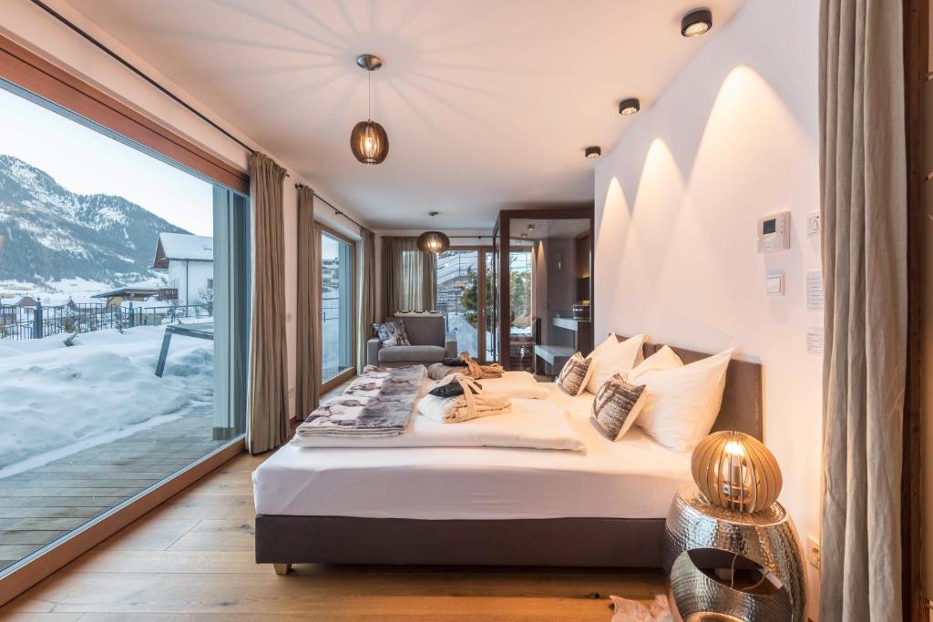 a bedroom with a bed and a large window at Paruda Mountainchalet in Ortisei