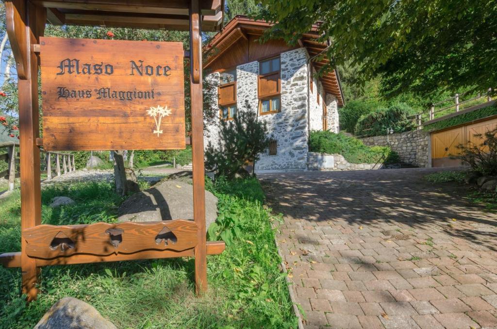 a sign in front of a house with a building at Maso Noce Est in Mezzana