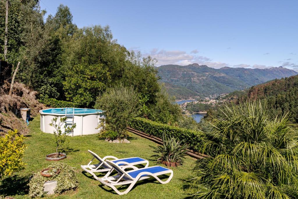 two lounge chairs and a pool in a yard at Quintinha Da Aldida - Gerês in Vieira do Minho