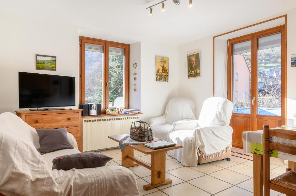 a living room with two chairs and a flat screen tv at Le Gîte À Mamie in Orbey