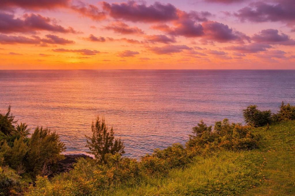 a sunset over the ocean with the sky and clouds at NEW Sunset Cove Hale Breathtaking View Pool AC in Princeville