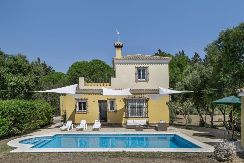 a yellow house with a pool in front of it at Chalet Independiete Con Piscina in Cádiz
