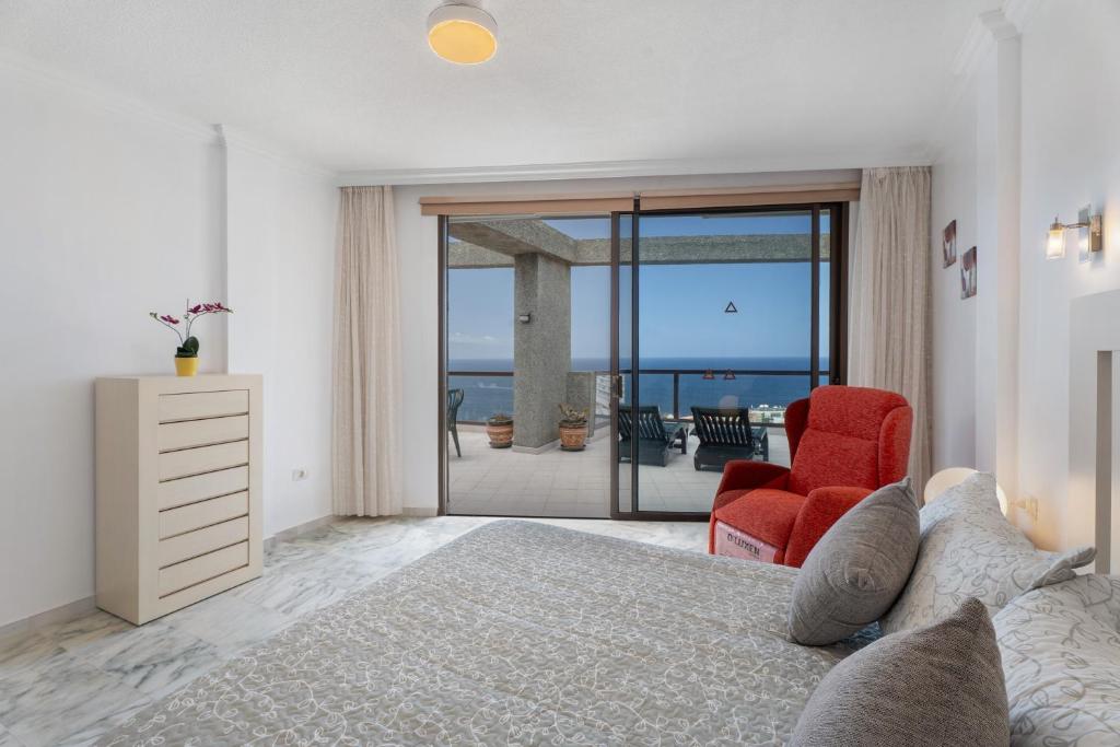 a bedroom with a bed and a view of the ocean at Al Mar Los Gigantes in Puerto de Santiago