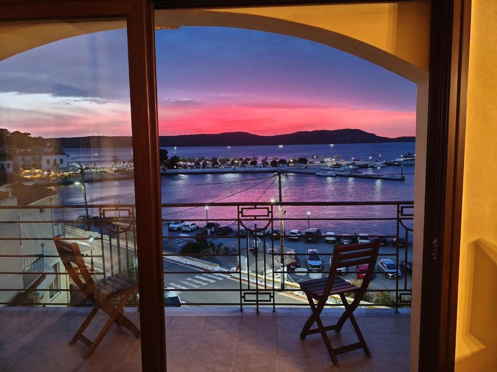ein Balkon mit zwei Stühlen und Blick auf einen Hafen in der Unterkunft Pylos before midnight in Pylos