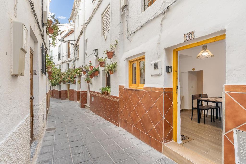 a street with white buildings and a yellow door at Alicia's House in Granada