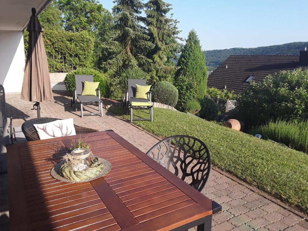 a wooden table and chairs on a patio at Ferienwohnung Bieniussa 3 in Gemünden