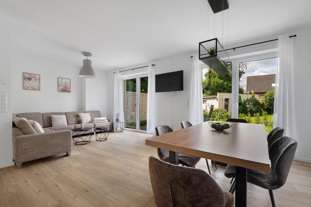 a living room with a table and chairs and a couch at Das Strandhaus am Dümmer See in Lembruch