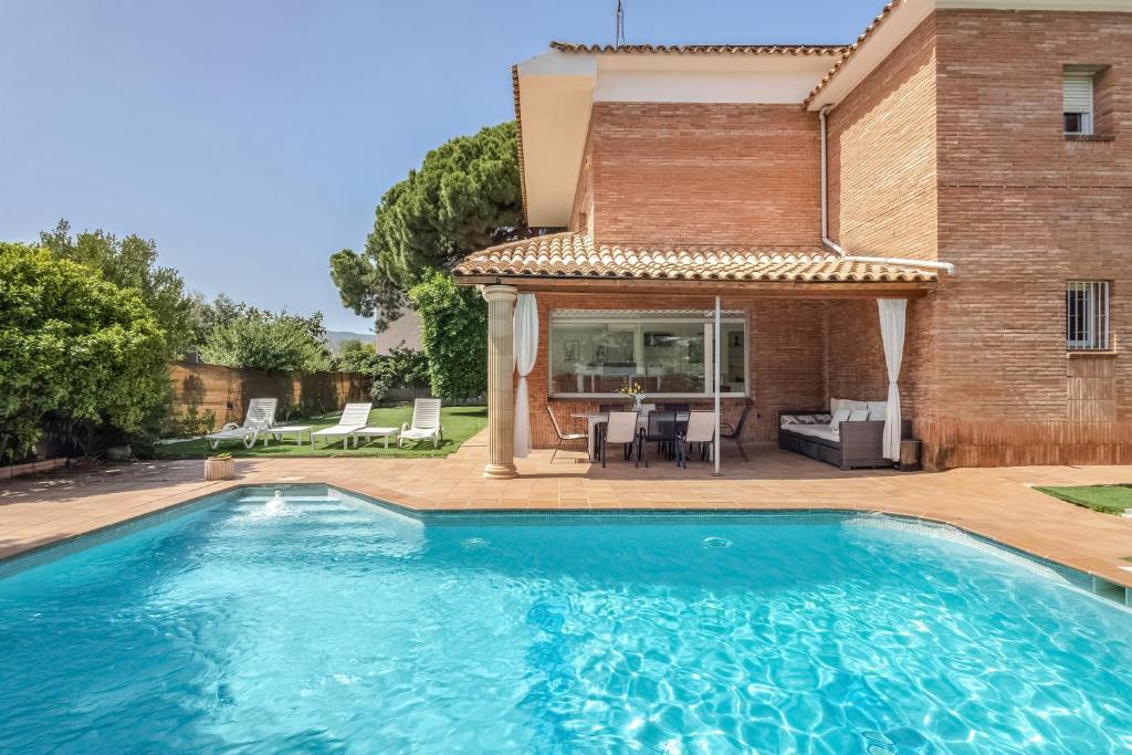a swimming pool in front of a house at Villa Masnou in El Masnou