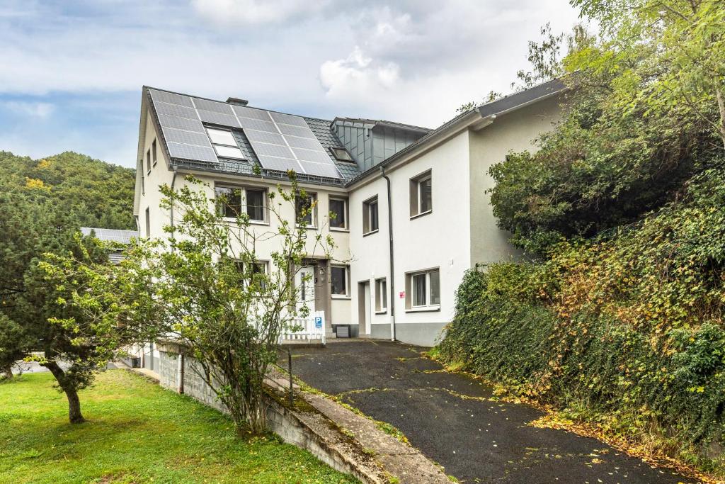 a white house with solar panels on it at Großes Ferienhaus Engelsdorf in Zweifelscheid