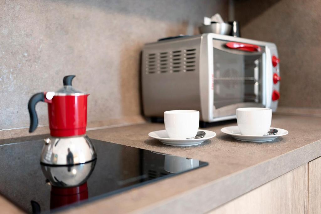 a counter with two coffee cups and a microwave at Casa vacanza A Cola - con Jacuzzi in Rocchetta Nervina