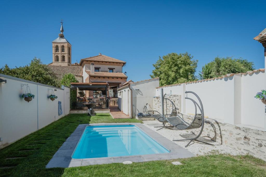 a backyard with a swimming pool and a white fence at La Antigua Taberna - Nieva in Nieva