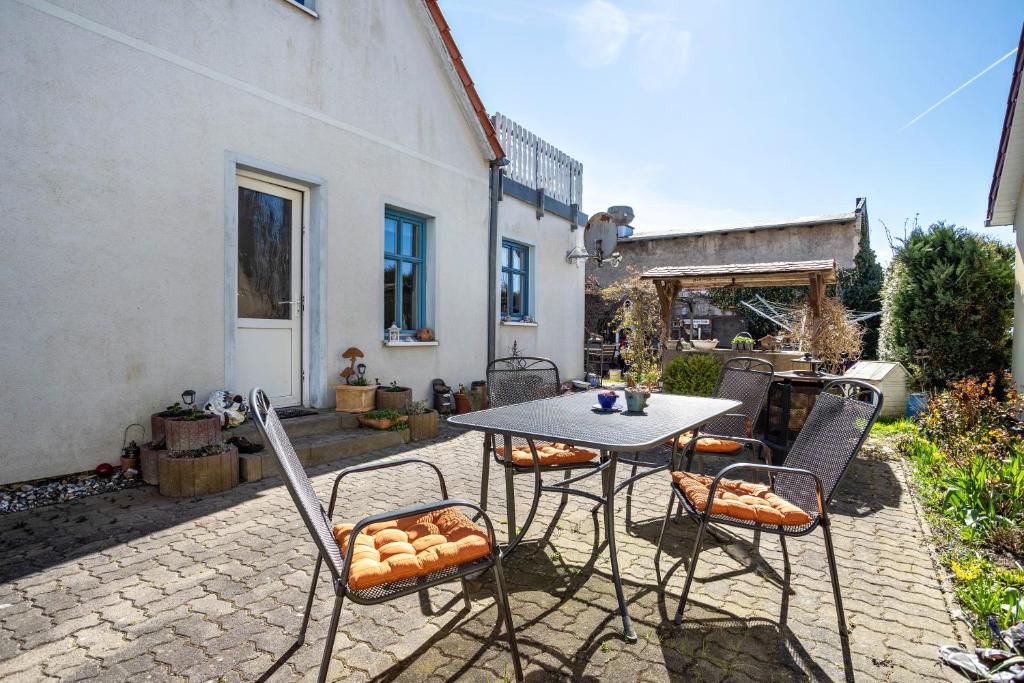 a patio with a table and chairs in a yard at Ferienwohnung Blütenzauber in Sagard