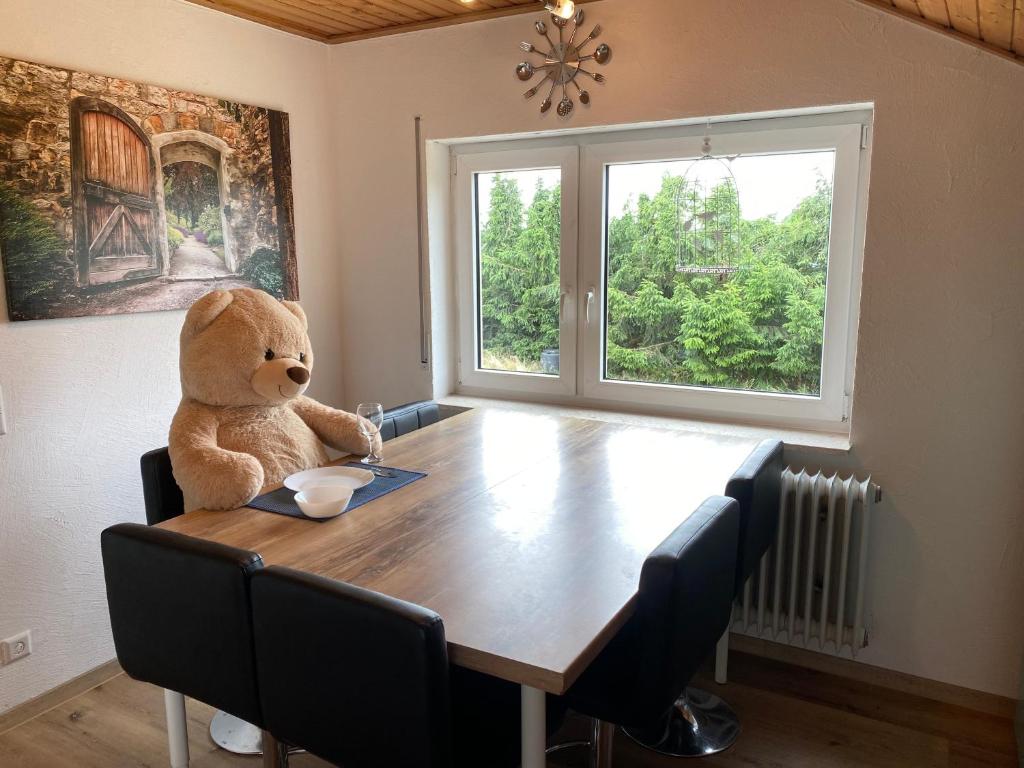 a teddy bear sitting at a table in a dining room at Friedrichshafen im Grünen genießen in Friedrichshafen