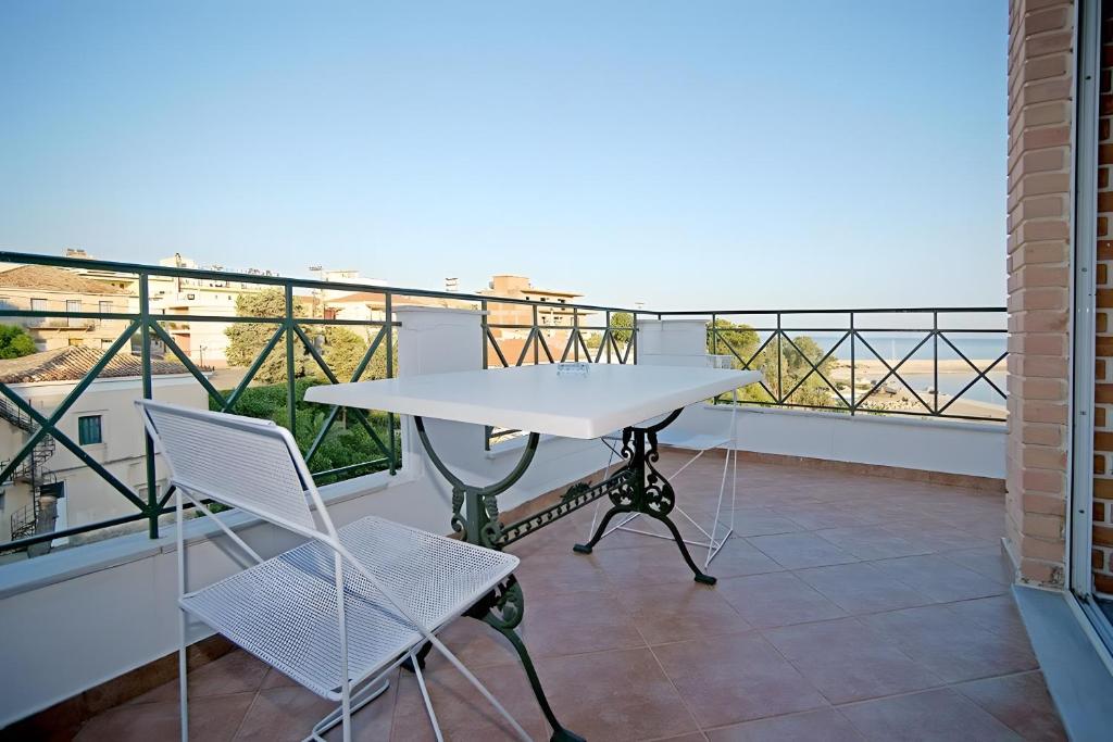 a table and chairs on a balcony with a view at A View From The Attic Window in Kyparissia