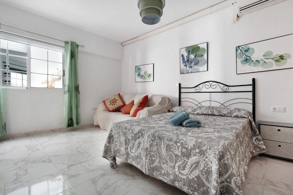 a bedroom with a bed and a couch at Casa Auxilia in Araya