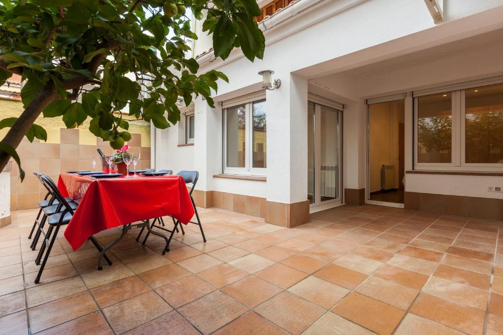 a table with a red table cloth on a patio at Lemon Tree Apartment in Canet de Mar