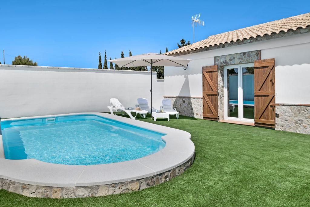 a backyard with a swimming pool and a house at Casa Faquinse La Muela 1 in Vejer de la Frontera