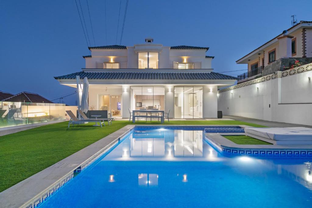 a villa with a swimming pool in front of a house at Private Villa Candelaria in Candelaria
