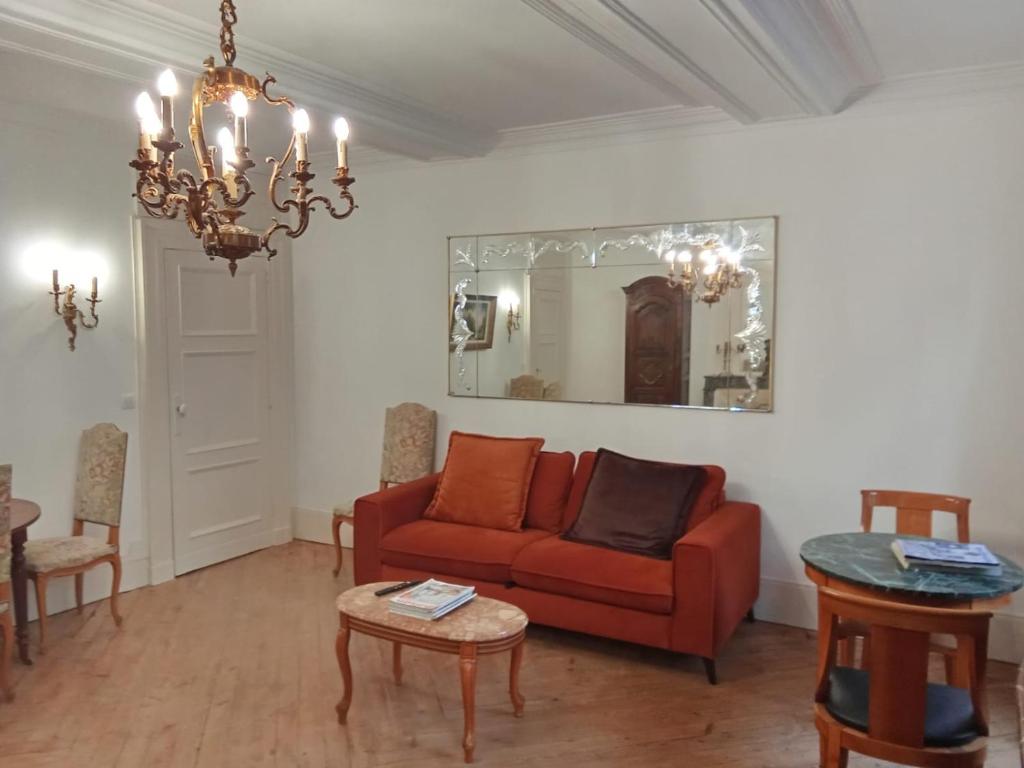 a living room with a red couch and a table at Le Royal in Bayeux