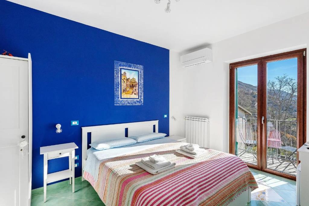 a blue and white bedroom with a bed and a window at Coast 2 Coast in Agerola