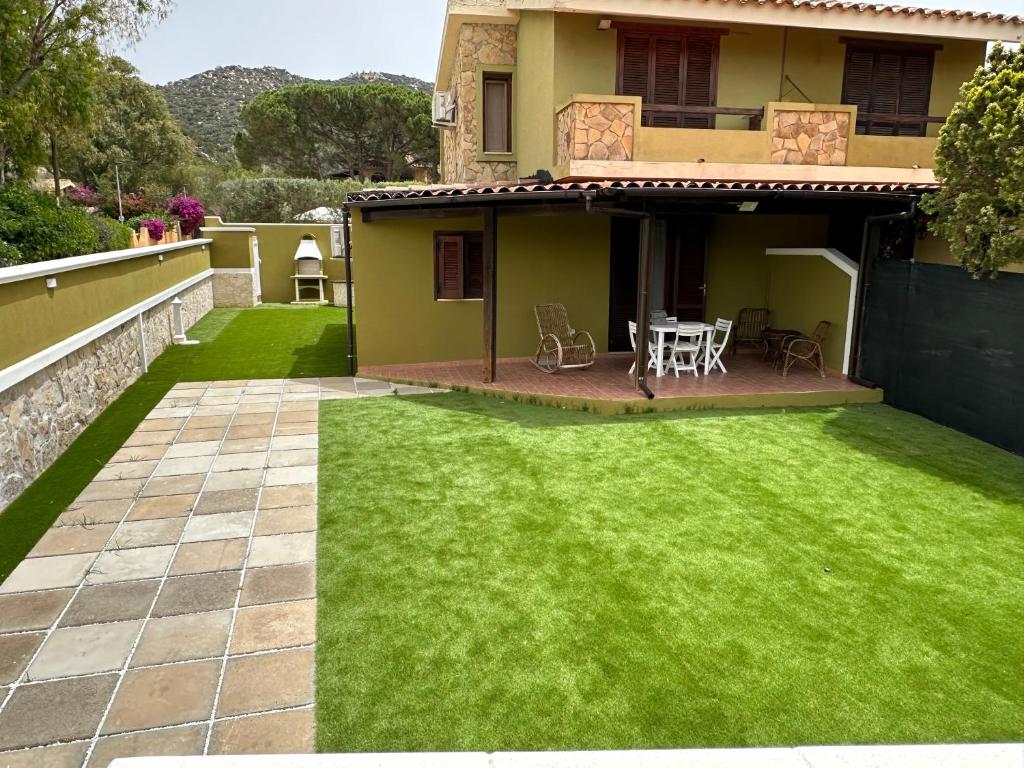 a yard with green grass and a house at Villa Balbi in Torre delle Stelle