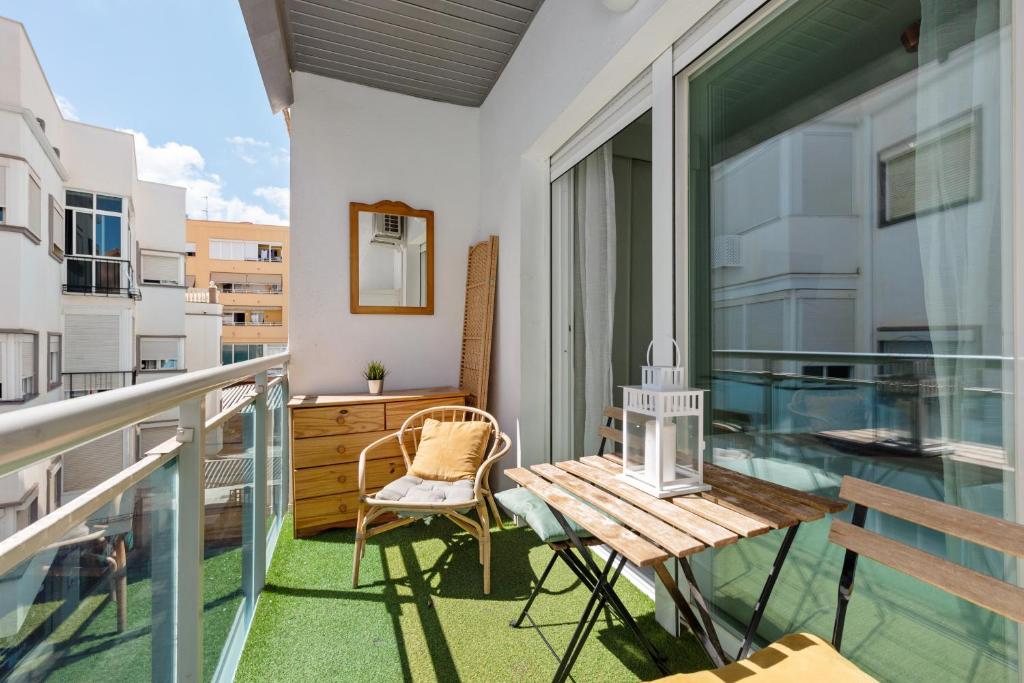 a balcony with a wooden table and chairs on it at Plata Centro in Torremolinos