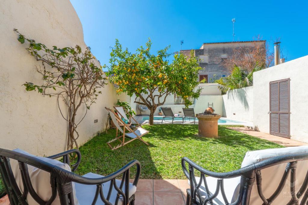 a patio with chairs and trees in a yard at Casa Llimoner con piscina in Sant Llorenç des Cardassar