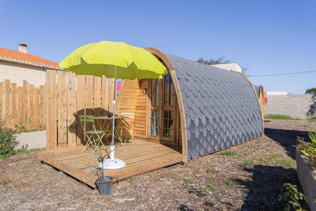 a yurt with a table and an umbrella at Pod Anis in Saint-André