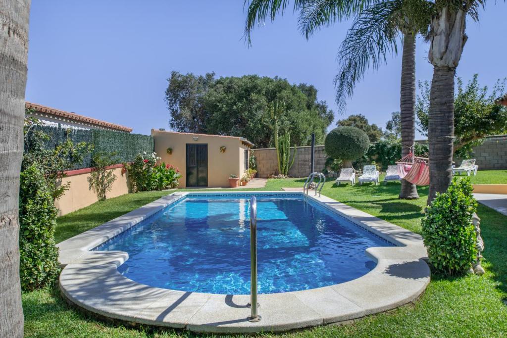 a swimming pool in the yard of a house with palm trees at Casa La Muela in La Muela