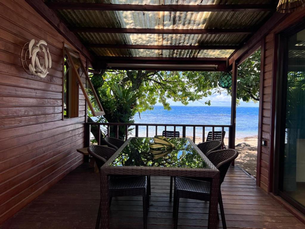 a table on a porch with a view of the ocean at Tahiti Sunrise Beach in Vaitoare