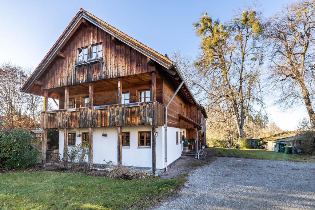 a large wooden house with a white garage at Haus am Bach in Benediktbeuern