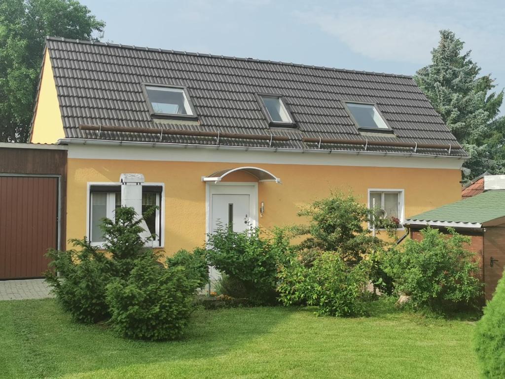 a yellow house with a black roof at Ferienhaus Enger in Saalfeld