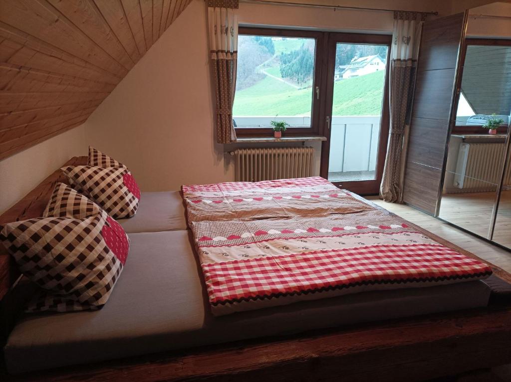 a bed sitting in a room with a window at Ferienwohnung Wiesenblick in Oberharmersbach