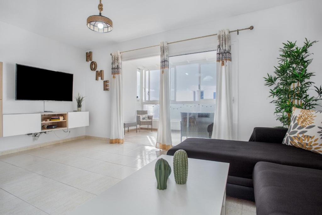a living room with a couch and a tv at Casa Dragos in Costa Teguise