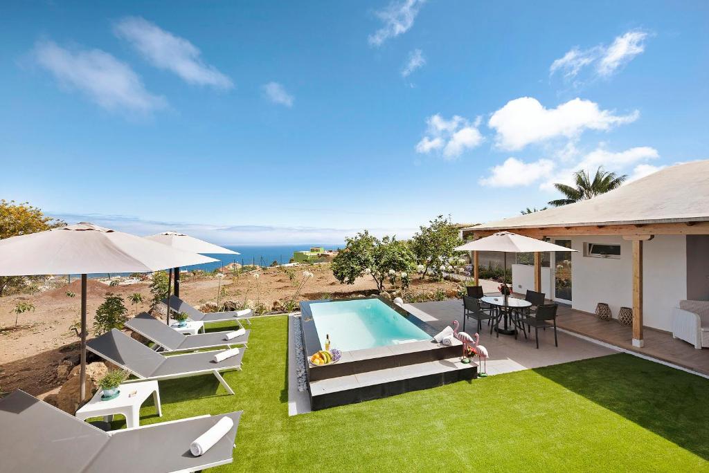 a backyard with a swimming pool and lawnitures at Casa Adayeim 1 in Icod de los Vinos
