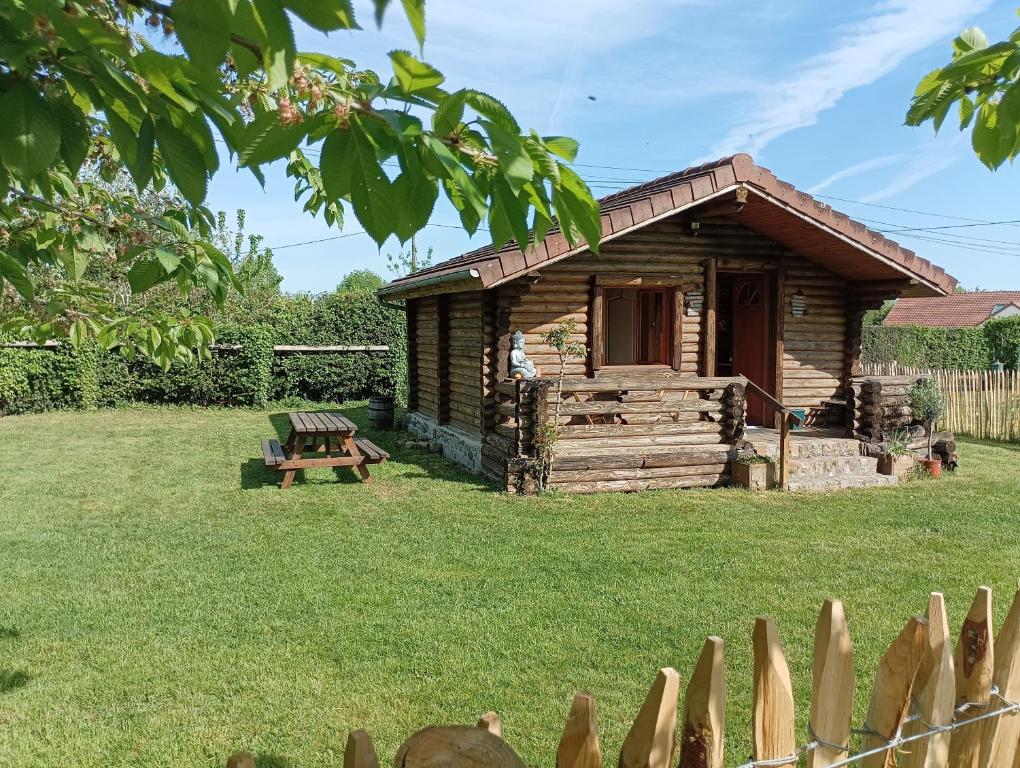 a log cabin in a yard with a fence at Chalet Idéal Randonnée in La Chapelle-Yvon
