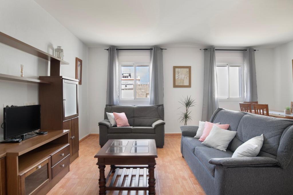 a living room with two couches and a tv at Piso Ana Paula 1 in Conil de la Frontera