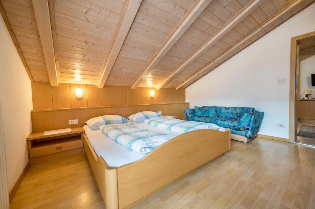 a bedroom with a bed and two blue chairs at App Sonne Nr 22 in Lutago